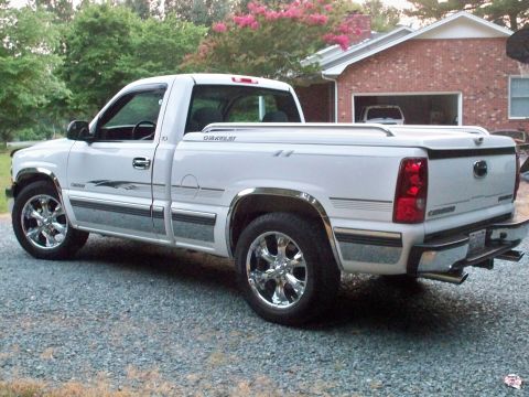 2002 Chevrolet Silverado 1500 - This white 2002 Chevrolet Silverado 1500 pickup truck is parked outside a brick house.