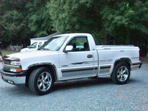 2002 Chevrolet Silverado 1500 - This 2002 Chevrolet Silverado 1500 pickup truck is parked outside with trees and a building behind it.