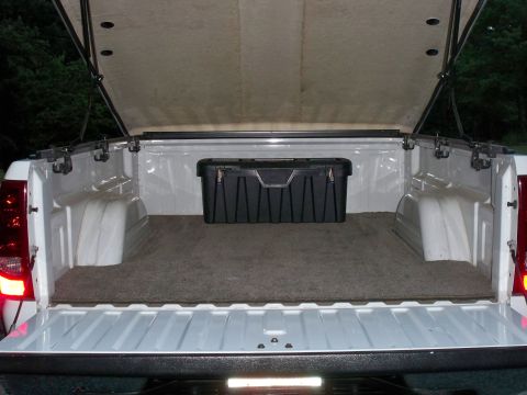 2002 Chevrolet Silverado 1500 - The rear of a white pickup truck is shown with the tailgate down and a black toolbox in the bed.