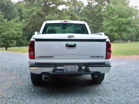 2002 Chevrolet Silverado 1500 - Rear view of a white Chevrolet Silverado pickup truck with a tonneau cover and chrome bumper.