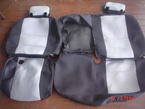 2005 Ford Excursion - Car seat covers are displayed on a wooden surface, likely for sale or storage.