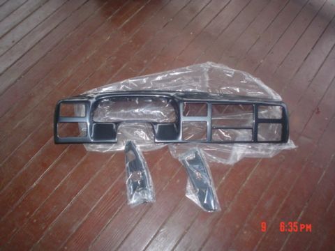 2005 Ford Excursion - Dashboard trim pieces are laid out on a wooden floor, covered in plastic wrap.