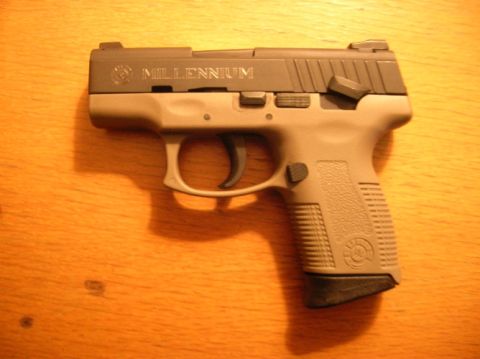 1996 Ford Bronco - A Millennium pistol is shown resting on a wooden table. The text 'MILLENNIUM' is visible on the slide.