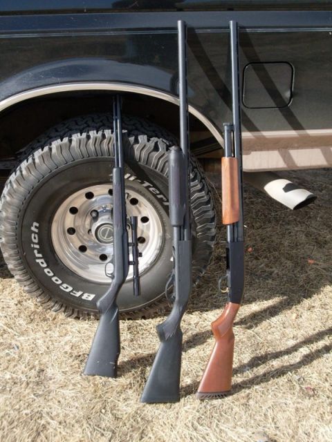 1996 Ford Bronco - Three rifles are displayed next to the tire and fender of a black SUV.