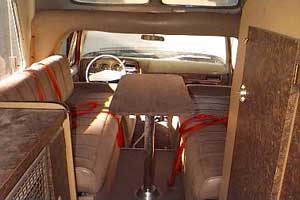 1991 Ford Bronco - The interior of a van shows seating, a table, and storage compartments.