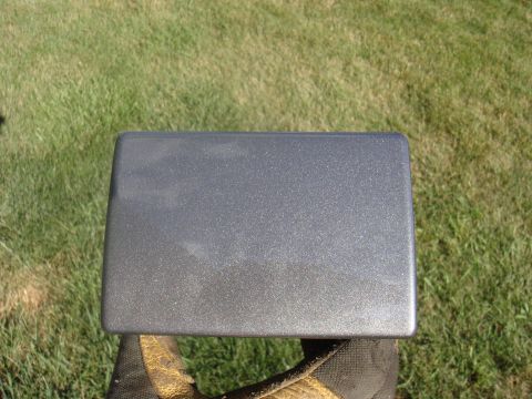 1979 Ford F-250 - A gray metallic rectangular part is held in a gloved hand outdoors.