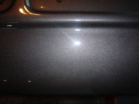 1979 Ford F-250 - Metallic grey paint detail on a vehicle body panel, showing reflections and texture.