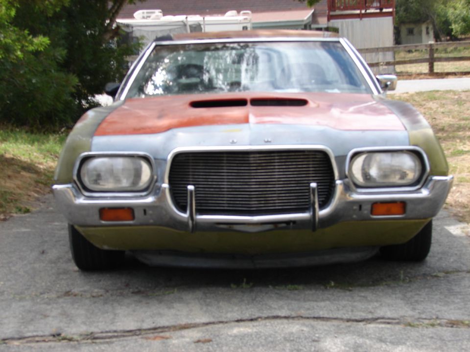 Patchwork primer 1970s Ford front end with billet grille and chrome bumper guards