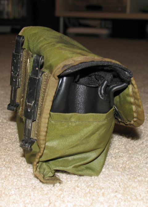 1984 Ford Bronco - A close-up view of a green canvas pouch with black buckles, possibly a military surplus item.