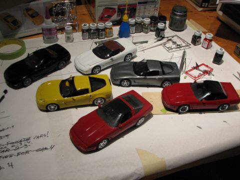 2003 Ford Crown Victoria - Model car building supplies and several Corvette models are laid out on a table.