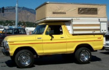 1991 Ford Bronco - This yellow Ford Bronco is equipped with a camper shell, suggesting it's ready for outdoor adventures.