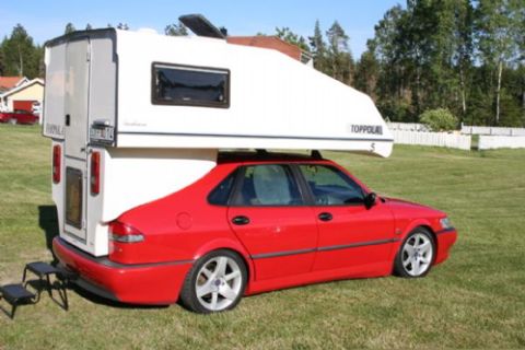 1991 Ford Bronco - A red sedan is fitted with a white camper shell, creating a makeshift RV for outdoor adventures.