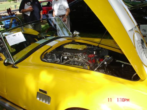 1978 Ford Mustang II - Close-up of a yellow sports car's engine bay at a car show.
