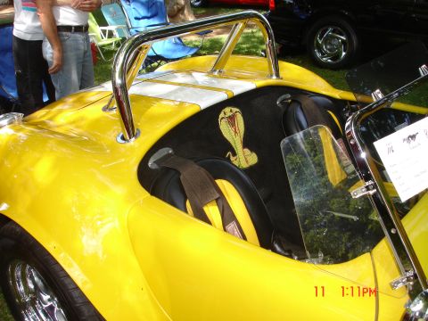 1978 Ford Mustang II - A bright yellow convertible with a cobra emblem on the seatback is shown at an outdoor event.