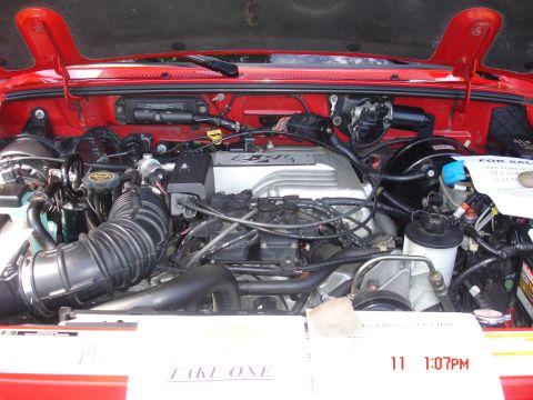 1978 Ford Mustang II - Engine bay of a red vehicle, a V6 4.0L engine and a 'FOR SALE' sign with details about the vehicle.