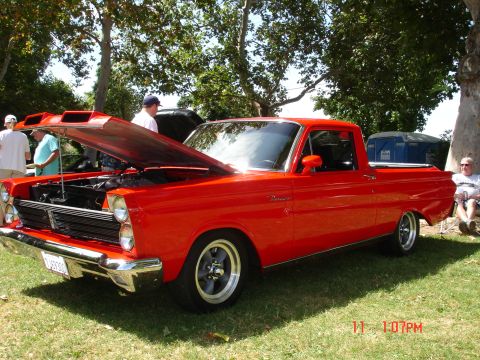 1978 Ford Mustang II - A red Mercury Comet pickup truck is displayed with its hood open at an outdoor car show.