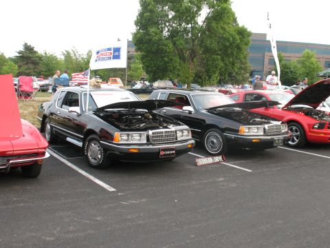 1985 Mercury Cougar - A black 1985 Mercury Cougar is displayed with its hood open, alongside other vehicles at an outdoor event.