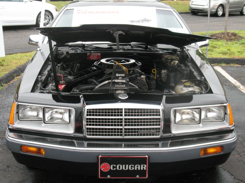 1985 Mercury Cougar with hood open showing engine bay and 'Best of Show COUGAR' sign