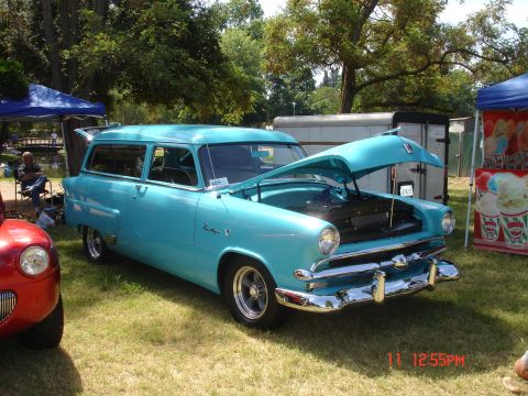 1978 Ford Mustang II - A turquoise station wagon is displayed with its hood open at an outdoor event.