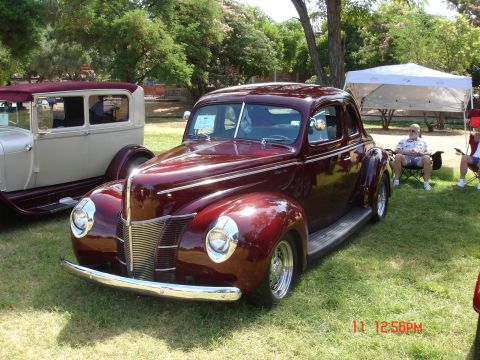 1978 Ford Mustang II - A classic maroon 1940 Ford coupe is displayed on a grassy lawn next to another vintage vehicle.