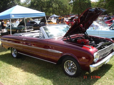 1978 Ford Mustang II - A maroon 1963 Ford Falcon convertible is displayed at a car show with its hood open.