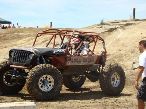 1989 Ford Bronco - Custom buggy with roll cage and large tires navigates a dirt course, "50 ROCK RACING" text is visible on the side.