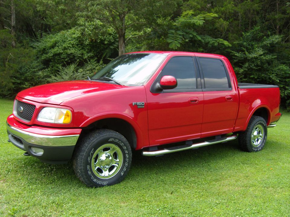 Red pickup truck side view. F-150 badge visible