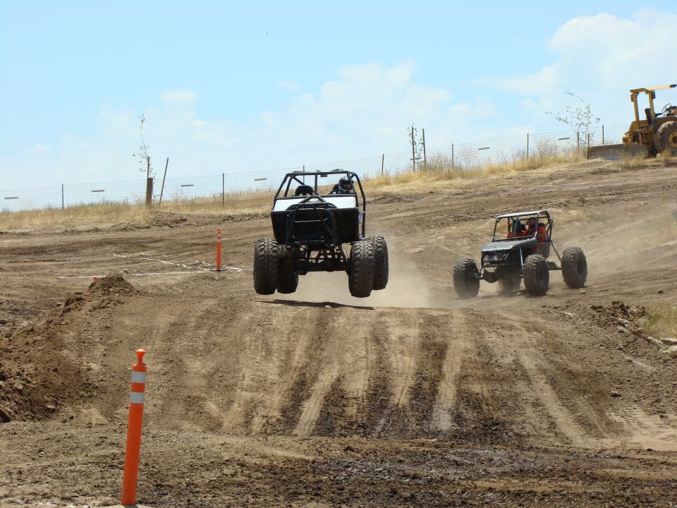 Off-road buggy mid-air, rear view, with another buggy behind
