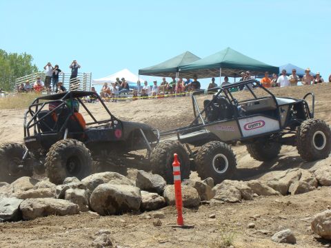 1989 Ford Bronco - Competitors tackle a challenging rock crawling course under a clear sky.