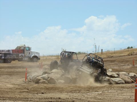 1989 Ford Bronco - Off-road vehicles tackle a challenging rock obstacle during a race event.
