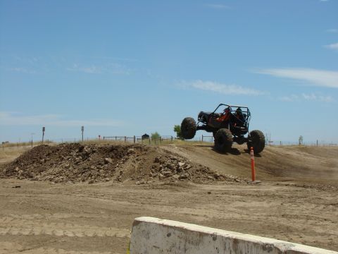 1989 Ford Bronco - Custom off-road buggy mid-air during an event on a dirt track.