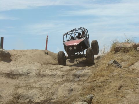 1989 Ford Bronco - This buggy is navigating a rocky, sandy terrain under a partly cloudy sky.