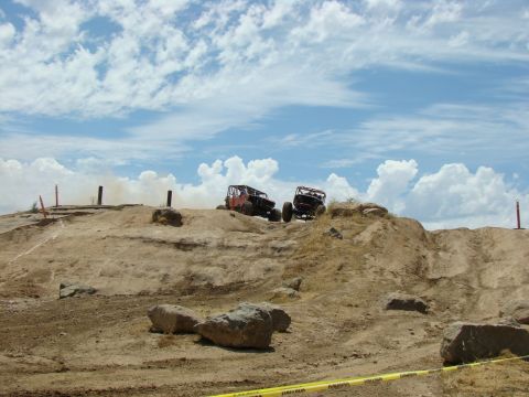 1989 Ford Bronco - Off-road vehicles navigate a challenging rocky terrain during a race event.