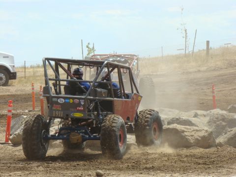 1989 Ford Bronco - Two off-road buggies navigate a dusty, rocky course during a race event.