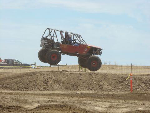 1989 Ford Bronco - This custom-built buggy is mid-air during a race event, its extreme off-road capabilities.