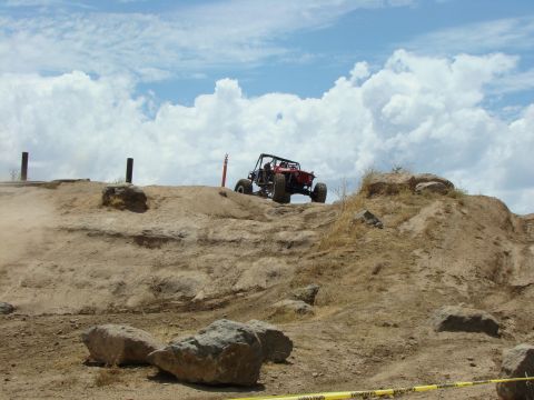 1989 Ford Bronco - Off-road buggy navigates a challenging rocky terrain on a sunny day.