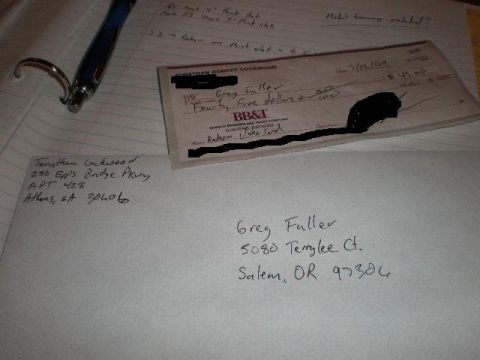 1986 Ford Bronco - A check and envelope are laid out on lined paper with a pen.