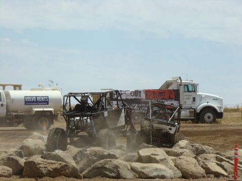 1989 Ford Bronco - Off-road vehicles tackle a challenging rock obstacle course under a partly cloudy sky.