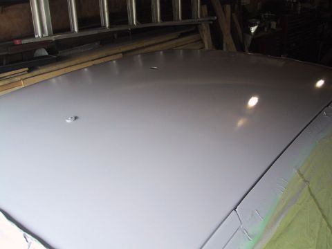 2003 Ford Crown Victoria - The top of a car is visible, with reflections on its surface, in what appears to be a workshop.