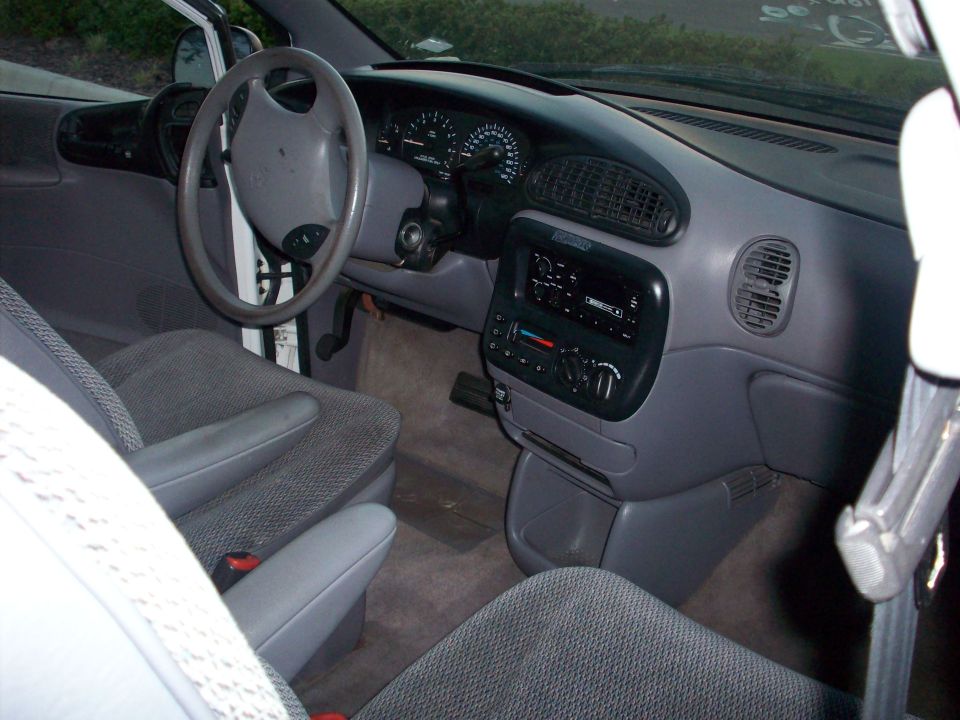 Minivan interior showing dashboard, steering wheel, and front seats