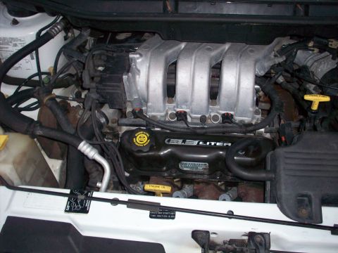 1985 Ford Bronco - Close-up of a 3.3L V6 engine, likely from a minivan or sedan, with a silver intake manifold and black valve covers.