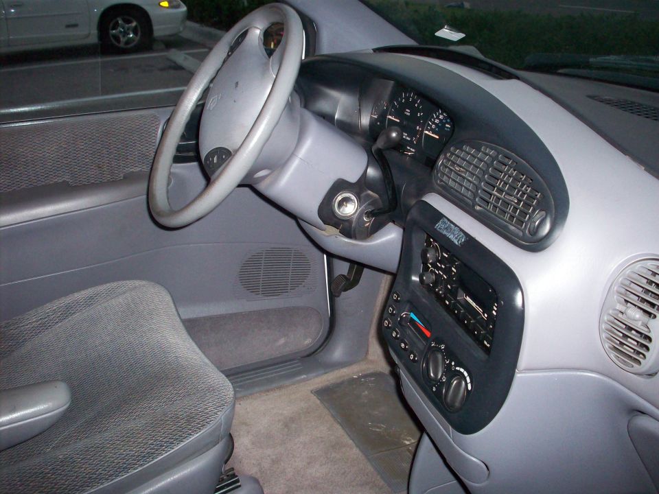 Interior of a minivan showing the steering wheel, dashboard, radio, and driver's seat