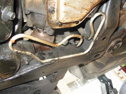 1997 Pontiac Grand Prix - Power steering return line with leak caused by rubbing on oil pan. The leak is on the left side right above the drop.