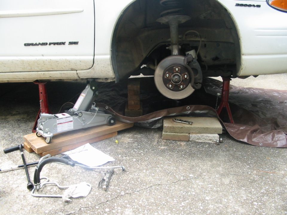 Car jacked up with passenger tire removed.