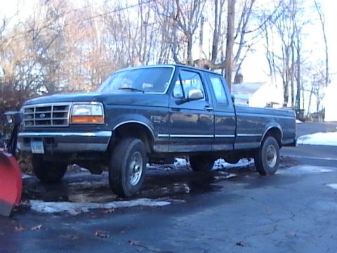 1990 Ford Bronco - This dark blue Ford F-250 pickup truck appears to be from the early to mid-1990s and is equipped with a snow plow.