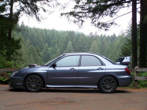 1998 Subaru Legacy - Side view of a gray Subaru WRX STI sedan with a prominent rear spoiler and hood scoop.