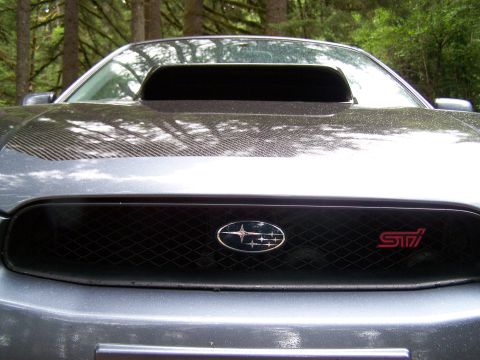 1998 Subaru Legacy - A Subaru WRX STI is parked outdoors with trees in the background.