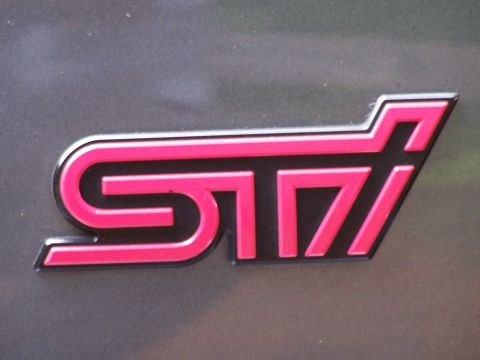 1998 Subaru Legacy - Close-up of a pink STI badge, indicating a performance trim level.