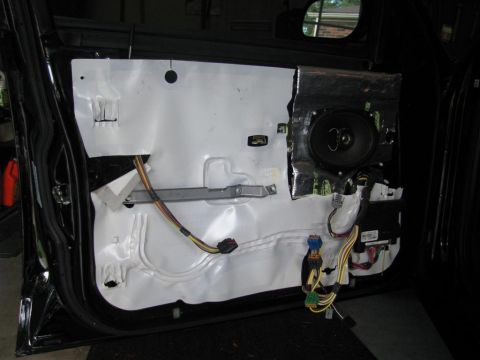2003 Mercury Marauder - Interior of a car door with the panel removed, exposing the speaker and wiring harness.
