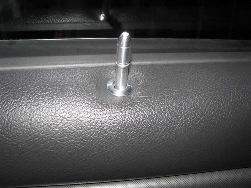 Door lock pin on textured gray interior panel